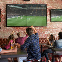 Friends,Watching,Game,In,Sports,Bar,On,Screens,Celebrating